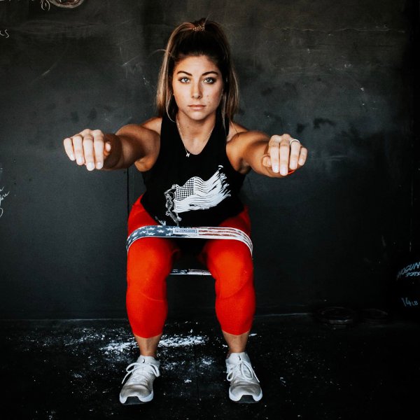 A fit woman performing squats in a gym, showcasing strength and determination.